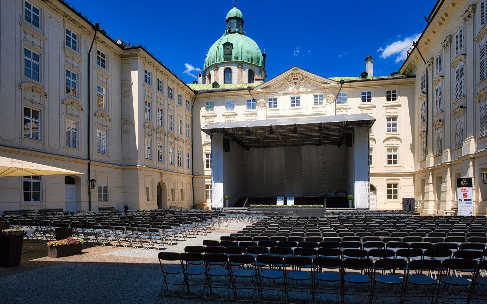 A courtyard set with chairs before an audience arrives